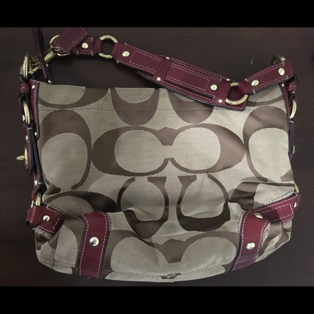 Coach brown “C” bag with burgundy leather straps.